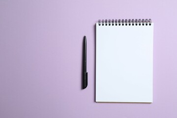 Flat lay with pen and notebook on color  background, top view