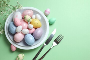 Easter decor concept. Top view photo of colorful eggs in a plate on pastel background