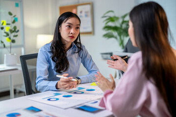 Two women are talking in a meeting room