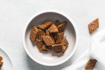 Overhead view of groundnut cake on a white plate, top view of nkatie cake or peanut cake on a plate, candy bar made with roasted peanuts and sugar