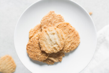 Overhead view of gurundi chips on a white plate, top view of nigerian coconut biscuits, Nigerian coconut cookies made with coconut and cassava