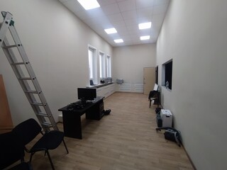 Interior of a modern office with white walls and wooden floor.