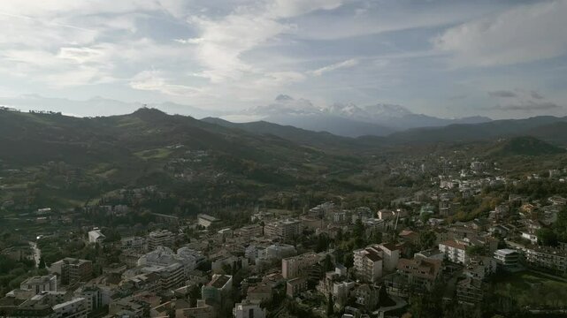 A stunning drone view of Teramo, Italy: rolling green hills, historic architecture, and vibrant cityscapes nestled in the Apennines. Breathtaking aerial perspectives!