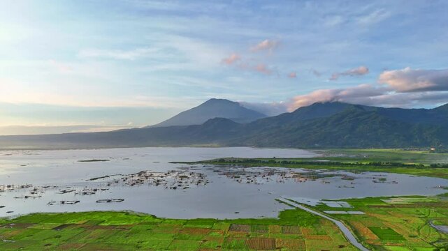 Aerial view of Rawa Pening lake with green plantation on the lake side in the morning. Scenery of lake, green plantation on mountain. Indonesia.