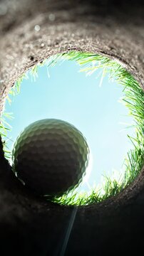 Super slow motion of falling golf ball into hole. Unique perspective angle of view. Filmed on high speed cinema camera, 1000fps.
