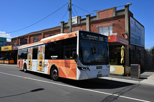 Route 703 bus, a Scania K310UB operated by Ventura, travelling past Centre Rd shops and restaurants during a sunny day