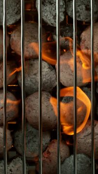 Super slow motion of burning charcoal on grill grid. Filmed on high speed cinema camera, 1000 fps. Top view. Vertical Aspect Ratio.