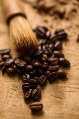 Close up of roasted coffee beans on brown wooden board. Selective focus on blurred background.