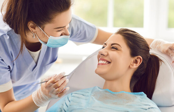 Dentist doctor working female dental surgeon during health care professional dentistry for teeth, gums, young smiling happy woman patient visiting stomatologist regular check up, good treatment result - Powered by Adobe