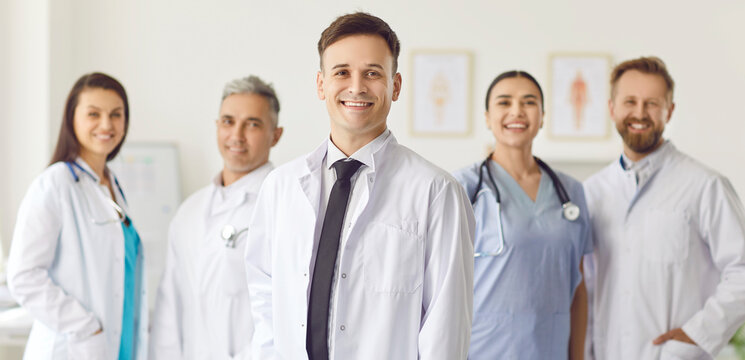 Group of happy doctors standing in the office, close-up. Concept of a professional ambulance team. Portrait of hospital staff in uniform with stethoscopes. Therapy team meeting, community