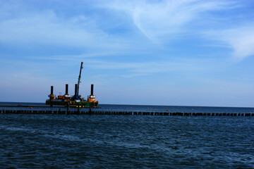 Obraz premium Polish Baltic Sea beautiful blue sea waves sand and beach drilling platform oil rig