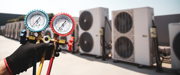 Electrical conditioning service technician using measuring manifold gauge checking HVAC condition...
