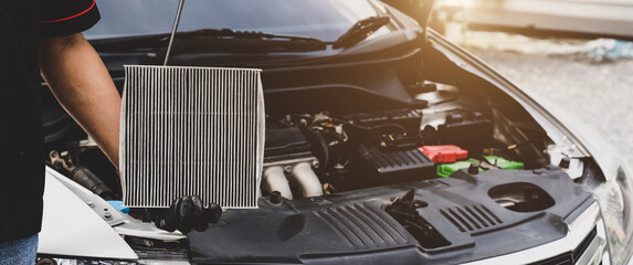 Car care maintenance servicing technician or auto mechanic holding car air conditioner filter for check and clean dirty or fix repair heat have engine problem or replace new change air filter.