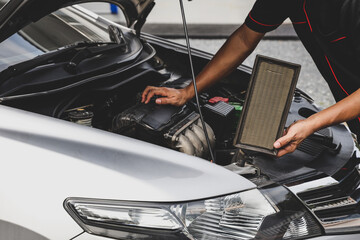 Car care maintenance servicing technician or auto mechanic holding car air conditioner filter for...