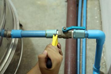 Plumber using a wrench to repair a water pipe. Concept of water pump maintenance fix water plumbing leaks drop or house bathroom service or cleaning clogged pipes is dirty or rusty.