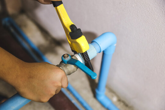 Plumber using a wrench to repair a water pipe. Concept of water pump maintenance fix water plumbing leaks drop or house bathroom service or cleaning clogged pipes is dirty or rusty.
