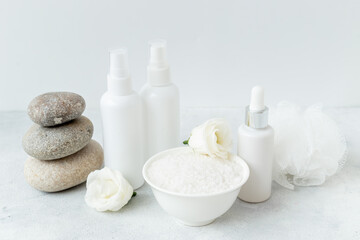 Blank white bottles of skin care cosmetics with roses