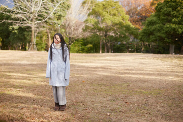 冬の朝の公園で元気で楽しく遊んでいる小学生の女の子の様子