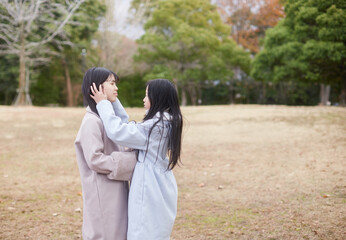 Naklejka premium 冬の朝の公園で元気で楽しく遊んでいる子供姉妹の姿