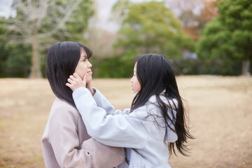 冬の朝の公園で元気で楽しく遊んでいる子供姉妹の姿