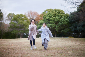 冬の朝の公園で元気で楽しく遊んでいる子供姉妹の姿