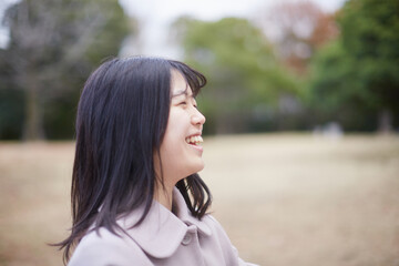 冬の朝の公園で元気で楽しく遊んでいる女子高校生の姿