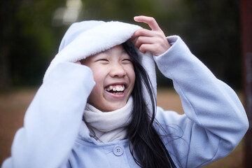冬の朝の公園で元気で楽しく遊んでいる小学生の女の子の様子