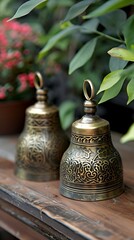 traditional brass bells with intricate designs placed on wooden table
