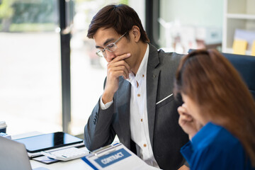 Stressed business team using a tablet to and analysis graph company financial.