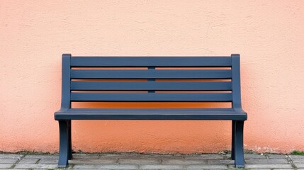 Dark Bench Against a Soft Coral Wall in an Urban Setting