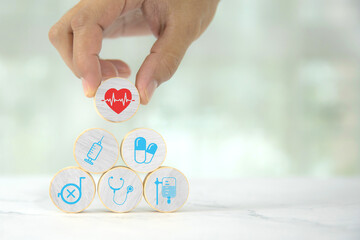 Hand chooses wooden toy stack with wellness medical care and healthy for family safety insurance plan or personnel sickness illness treatment concept.