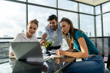 Group of diverse profession business people pointing at laptop displayed idea. Portrait of business team show marketing strategy present by laptop with statistic document scatter on table. Tracery.