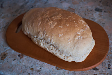Fresh rustic bread on kitchen board. Selective focus