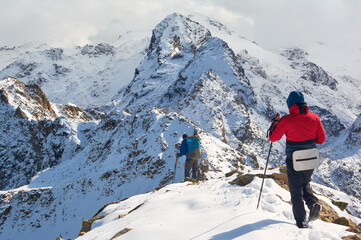 People walking on snow-capped peaks. Winter in the mountains. Views of snow-capped mountains.
