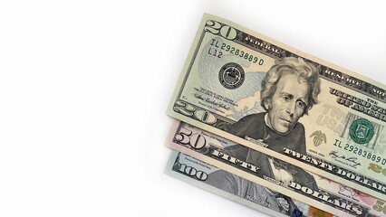 Stack of United States currency notes in denominations of 20 dollar bill, 50 dollar bill, 100 dollar bill, placed diagonally on a white background. Minimalistic composition suitable for financial