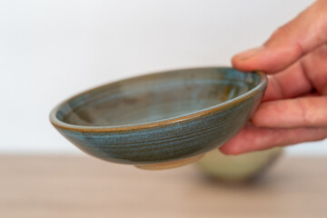 Handmade ceramic ramekin held by human hand. High quality photo
