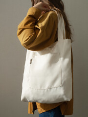 a white fabric bag on the girl's shoulder
