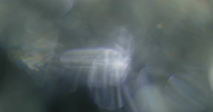 Refraction and Reflection of Sunlight through a rotating glass of water.  Shallow depth of field bokeh.  Overlay or background film type effect.