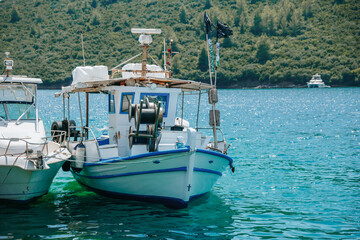 Fototapeta premium Small boat is docked in the water next to a larger boat