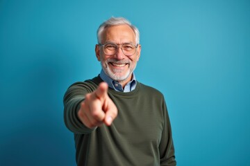 Fototapeta premium Happy Senior Man Pointing Forward Smiling Optimistically Perfect for Inspirational and Motivational Campaigns
