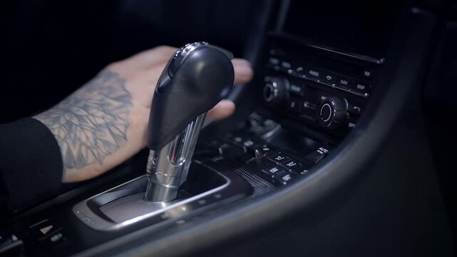 An intricate closeup view of the cars gear shift and the various dashboard controls
