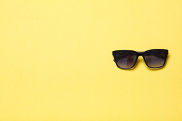 luxury fashionable sunglasses lying on yellow background, flatlay top view