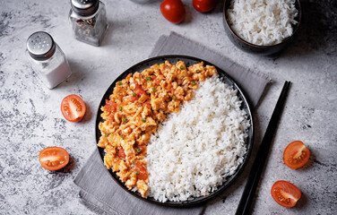 Tomato and eggs stir fry with rice in a plate