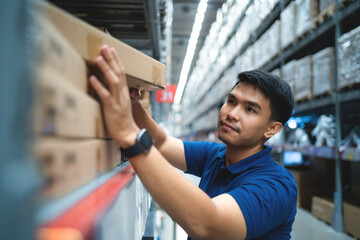 A man in a blue shirt is reaching for a box on a shelf. Concept of determination and focus as the...