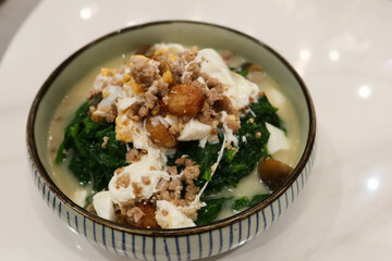 close up of Chinese Hong Kong Style Cantonese style preserved egg, salted egg minced pork with soup braised vegetables