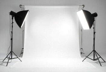 A white backdrop with two studio lights on stands, ready for a photoshoot