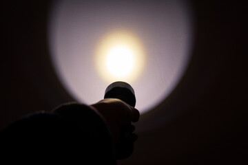 A hand holding a flashlight in the dark