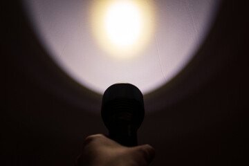 A hand holding a flashlight in the dark
