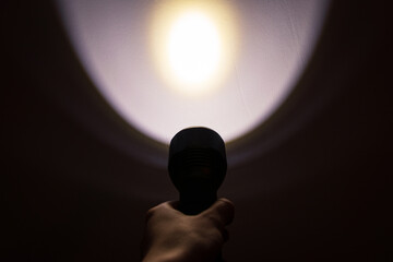 A hand holding a flashlight in the dark