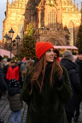 Christmas Market with Cathedral Backdrop
A young woman wearing an orange hat in front of a Christmas market and a majestic Gothic cathedral. Festive winter holiday vibes surrounded by historic archite